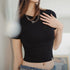 Person wearing a black knitted short-sleeve top with text overlay